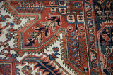 Detail of the hand-knotted pile showing serrated leaves and floral motifs in a vintage Heriz carpet.