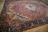 Angled perspective of a vintage Heriz carpet showcasing its stepped medallion and bold geometric design.