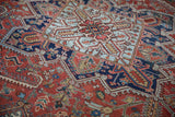 Close-up on the stepped, diamond-shaped medallion of a vintage hand-knotted Heriz carpet.