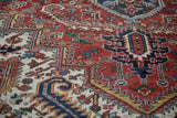 Angled detail view of the hand-knotted wool pile showing geometric motifs in red and blue.