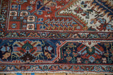 Unusual arabesque floral border of a vintage Heriz carpet in cherry red, navy blue, and beige.