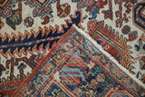 Folded corner of a vintage Heriz carpet reveals the detailed pile and hand-knotted back.