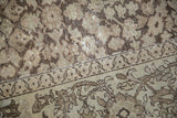 Distressed coffee brown border with worn beige field and shrub motif.