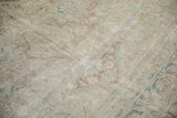 Distressed antique Kerman carpet showing areas of low pile, visible knot heads, and foundation.