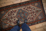 Black boots on a vintage Hamadan rug, highlighting its hexagonal medallion and cypress motifs.