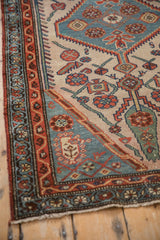 Corner detail of vintage Hamadan rug, showing light fringe and madder root red border.