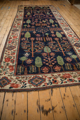 Baktiari rug border detail with madder root red roses and blue floral motifs on sand.