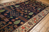 Vintage Baktiari runner's navy field, green cypress trees, and cochineal red floral border.