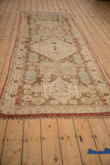 Distressed antique Caucasian runner: coffee brown, ivory, geometric medallions, and brick red accents.