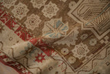 Distressed antique Caucasian rug detail with brick red star motif, ivory, and coffee brown abrash.