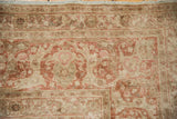 Distressed pile detail of antique Kerman carpet: terracotta and ivory Safavid-revival floral palmettes and fringe.