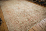 Distressed Kerman carpet's allover field of terracotta, sage, and ivory floral palmettes.