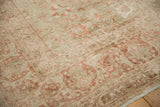 Muted terracotta floral palmettes and sage green border on a distressed antique Kerman carpet.