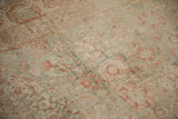 Detail of antique distressed Kerman carpet, showing soft floral palmettes in pale raspberry and sage green.