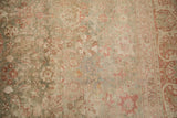 Aged Kerman carpet detail with faded raspberry and sage palmettes, reflecting time-softened patina.