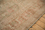 Aged terracotta and sage floral border with intact selvage on the distressed Kerman rug.
