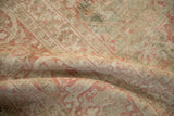 Patinaed pile of antique Kerman carpet showing raspberry and sage floral patterns.