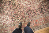 The detailed Herati field and raspberry red border of a low-pile vintage Persian Tabriz carpet.