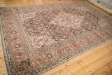 Angled view of a vintage Tabriz carpet, showing its intricate Herati pattern and time-softened colors.