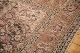 Corner view of a Persian Tabriz with raspberry Herati borders and secured side cord selvages.