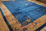 Angled view of an antique Peking carpet showing the open blue field and pictorial gold border.