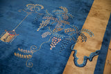 A close-up view of the pictorial lantern and scrolled vine on a blue antique Peking carpet.