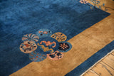 Corner medallion detail on an antique Peking carpet showing sapphire blue, gold, and dusty rose motifs.