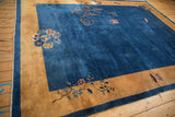 Antique Peking carpet from an angle, showing the pictorial tree and lantern on its blue field.