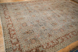 Distressed Tabriz carpet detail: faded blue and copper floral pattern, worn pile, tattered edge.