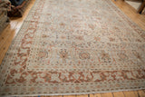 Distressed Tabriz carpet border showing faded scrolling arabesques and floral vinery in soft tones.