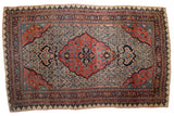 Antique Halvaie Bijar carpet with a red shield medallion and dragon arabesques on an ivory Herati field.