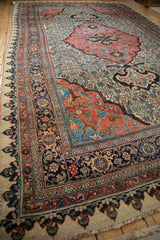 Dragon style arabesques in the madder red corner spandrel of an antique Persian Bijar carpet.