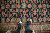 Antique Northwest Persian runner's navy blue field with floral lattice and geometric beige border.