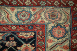 Antique Northwest Persian rug corner with madder red, navy, ivory floral motifs.
