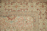 Antique Tabriz rug corner, intricate terracotta vines on ivory, with even wear revealing foundation.