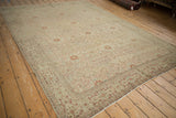 Antique distressed Tabriz carpet field with intricate terracotta vines and faded floral medallions.
