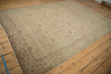 Distressed antique Tabriz rug corner with ivory, terracotta geometric border and vine motifs.