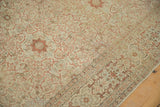 Distressed Tabriz carpet: intricate vine field meets geometric border in faded terracotta, ivory.