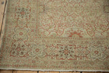 Distressed Antique Tabriz rug corner, geometric border, softly worn terracotta, ivory, and beige patterns.