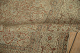Distressed pile of antique Tabriz carpet with softened ivory, terracotta, and powder blue motifs.