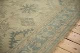 Close-up on the distressed low-pile texture of a vintage Oushak showing stylized guls.