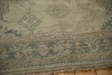 Close view of a distressed Oushak showing even wear to the knot heads and muted border.
