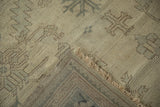 Hand-knotted construction and low, even pile on the corner of a distressed vintage Oushak rug.