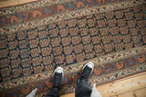 Antique Kurdish runner detail: navy field with repeating boteh motif, aubergine floral border.