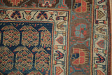 Close-up of antique Kurdish rug corner showing navy boteh field and patterned ivory, deep aubergine borders.