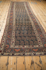 Antique Kurdish runner showing navy boteh field with pink grapefruit plants and an aubergine floral border.