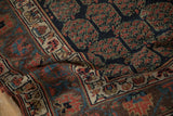 Detail of antique Kurdish runner: hand-knotted pile, indigo boteh, and ivory floral border.