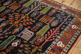 Vintage Bakhtiari garden design carpet: dark navy field, colorful shrubs, and red vine border.