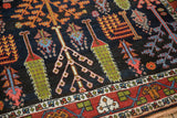 Bakhtiari garden rug section: navy field, cypress trees, sprawling shrubs, and red vine border.