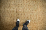 Overhead view of the worn texture and allover Herati motif on an antique distressed Tabriz rug.
